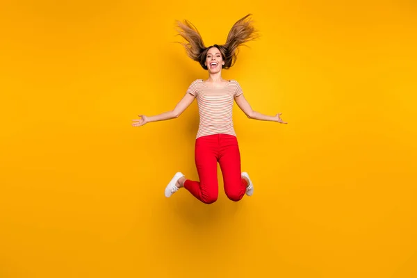 Full storlek foto av lekfull glad funky flicka har fritid hålla handen känner galen uttryck hoppa med hennes frisyr fallande flygande slitage casual stil t-shirt isolerad ljus färg bakgrund — Stockfoto