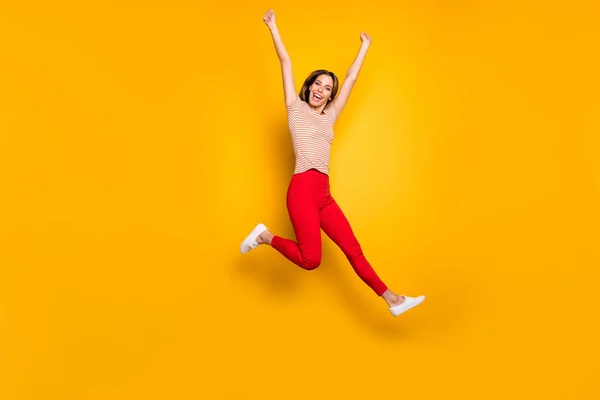 Helkroppsfoto av glad flicka höra vinna lotteri nyheter hoppa skrika ja höja nävar bära casual stil kläder isolerade över gul färg bakgrund — Stockfoto