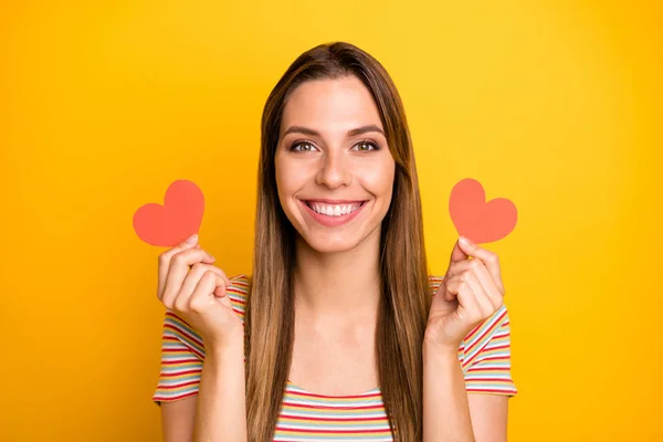 A mí me gusta. Primeros planos foto de la señora divertida cogida de la mano poco rojo papel corazones coqueta chica estado de ánimo expresando acuerdo desgaste casual rayas camiseta aislado color amarillo fondo — Foto de Stock