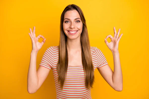 キーシンボルを示す素晴らしい女性のクローズアップ写真おもちゃの笑顔表現肯定的な態度を身に着けているカジュアルストライプTシャツ孤立黄色の背景 — ストック写真