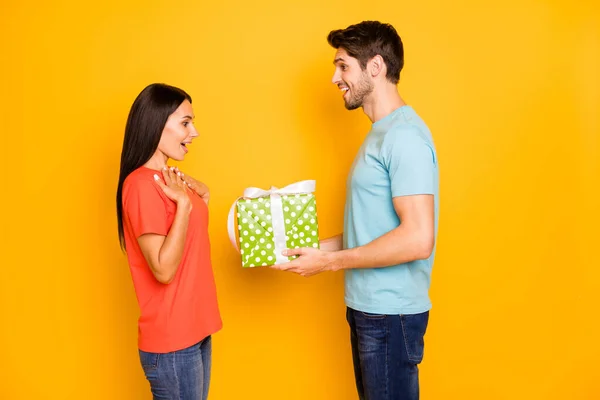 Profil fotografie dvou chlap dáma lidé drží ruce velké dárkové krabice romantika překvapení pro 8 března nosit ležérní trendy modrá oranžová trička džíny izolované žlutá barva pozadí — Stock fotografie