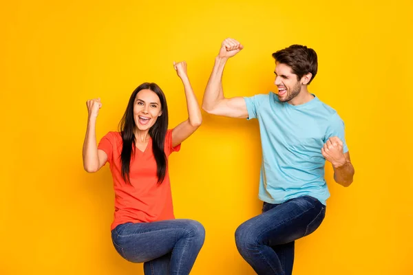 Photo of funny two people guy lady celebrating competition nyertes sportoló bajnokok viselnek alkalmi kék narancs pólók farmer elszigetelt sárga háttér — Stock Fotó