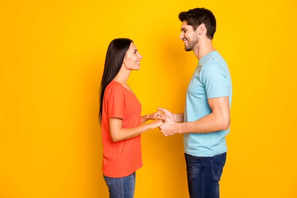 Profil photo de belle deux personnes couple gars et dame tenir bras regarder yeux romance amour déclaration porter casual bleu orange t-shirts jeans isolé sur fond de couleur jaune — Photo