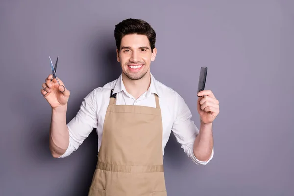 积极快乐的男人的画像发型师拿着剪刀梳子专业地准备好剪头发穿白色衬衫与灰色背景隔离 — 图库照片