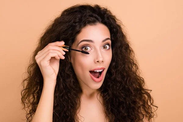 Close-up portrait of her she nice-looking charming cute lovely attractive winsome cheerful feminine girlish wavy-haired girl applying new cool black lash product isolated on beige background — 스톡 사진