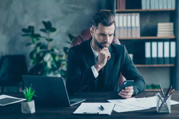 Foto de cara de negócios bonito segurando as mãos do telefone esperando colegas corporativos parceiros chamam desgaste blazer preto camisa branca gravata terno sentado grande cadeira escritório dentro de casa — Fotografia de Stock