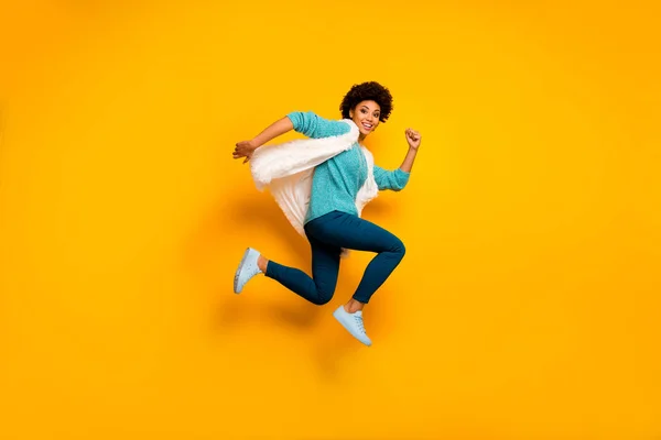 Volledige lengte foto profiel zijkant foto funky gek bruin haar afro amerikaans meisje jump run verkoop slijtage wit stijlvol trendy teal pullover blauw outfit geïsoleerd over helder glans kleur achtergrond — Stockfoto