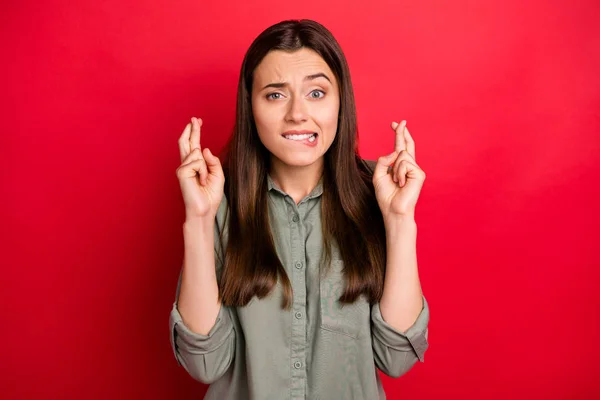 Close-up portret van haar ze mooi aantrekkelijk bezorgd nerveus bang rechte haren meisje in kaki shirt bidden gekruiste vingers geïsoleerd op heldere levendige glans levendige rode kleur achtergrond — Stockfoto