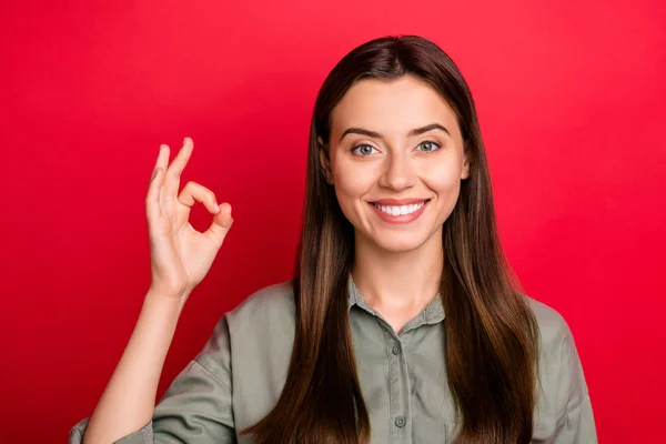 Close-up portret van haar ze mooie mooie mooie charmante leuke vrolijke vrolijke rechte haren meisje dragen kaki shirt tonen ok-teken geïsoleerd over heldere levendige glans levendige rode kleur achtergrond — Stockfoto