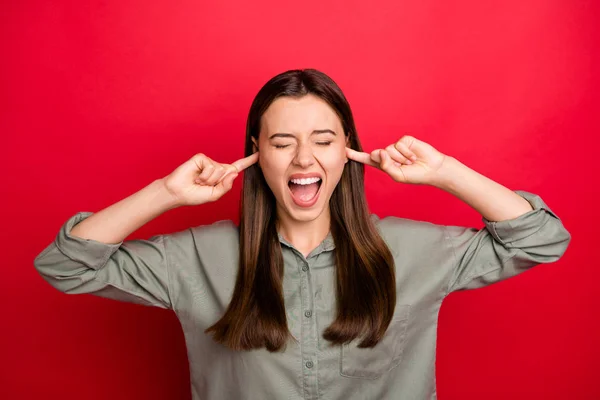 Primer plano retrato de ella ella agradable atractivo loco abrumado de pelo recto chica con camisa de color caqui cierre orejas burnout aislado sobre brillante brillo vivo vibrante color rojo fondo — Foto de Stock