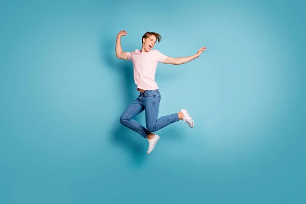 Портрет веселый энтузиаст парень наслаждаться весенними каникулами чувствовать себя сумасшедшие эмоции крик прыжок носить красивую одежду кроссовки изолированы на синем фоне — стоковое фото