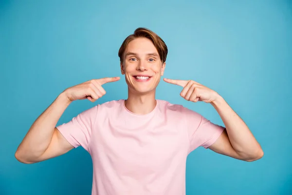 Porträtt av positiva glada killen har ortodontiska medicinska tänder behandling visar pekfinger strålande leende mun bära snygga kläder isolerad över blå färg bakgrund — Stockfoto