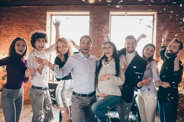 Foto de incríveis oito melhores amigos confetti queda organizando surpresa festa do bebê cumprimentando futuros pais jovens levantar as mãos formalwear restaurante dentro de casa — Fotografia de Stock