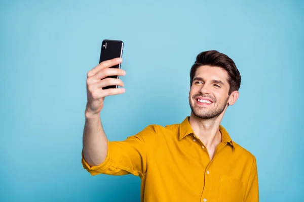 Photo d'un gars positif confiant et joyeux qui sourit en prenant du selfie dans un voyage isolé sur un fond de couleur bleu pastel — Photo