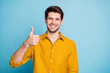 Photo of cheerful handsome funny funky guy smiling toothily showing you thumb up demonstrating quality of product isolated over pastel color background clipart
