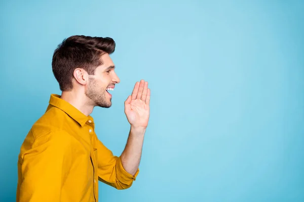 Photo of screaming man announcing some essential information for certain people with cheerful facial expression in yellow shirt empty space isolated over pastel blue color background