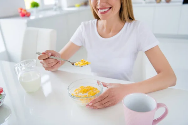 Abgeschnitten Foto von Hausfrau Hände halten Löffel Gießen frischer Milch Kochen Frühstück Cornflakes lecker gesunde Ernährung Konzept Sitztisch weiß Licht Küche drinnen — Stockfoto