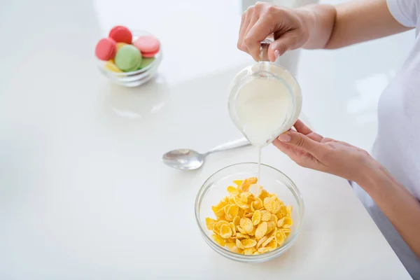 Cropped photo of housewife hands holding pouring milk jug cooking breakfast cornflakes healthy eating concept keeping to diet ignore sweets white light kitchen indoors — Stock Photo, Image