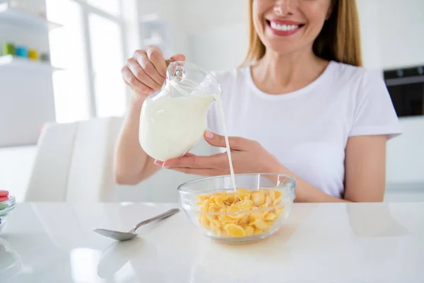 Beschnitten Foto von Hausfrau Hände halten Gießen frische Milch Kochen Frühstück Cornflakes lecker gesunde Ernährung Konzept weißes Licht Küche drinnen — Stockfoto