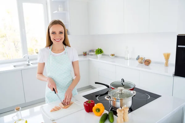 Photo of beautiful housewife cutting chicken meat enjoy weekend morning cooking tasty dinner family husband children stand bright light kitchen indoors — 스톡 사진