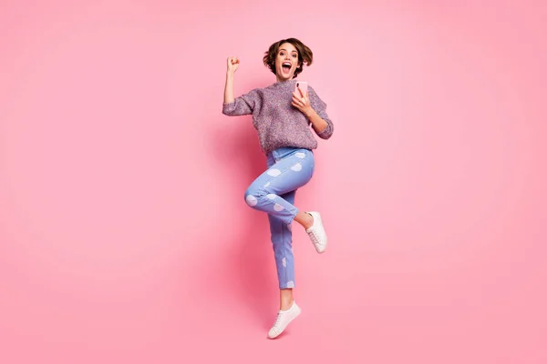 Full length body size view of her she nice attractive lovely pretty overjoyed cheerful cheery glad excited brown-haired girl using cell jumping great news isolated over pink pastel color background — 스톡 사진