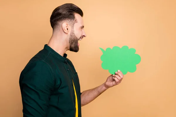 Profilfoto von attraktiven lustigen Kerl mit grünem Papier Geist Wolke schreien Ausdruck eigener Gedanken Plauderbox tragen lässig trendige Kleidung isoliert beige Farbe Hintergrund — Stockfoto