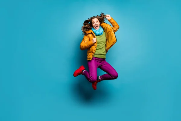 Foto de cuerpo completo de la señora bonita saltar alto celebrando logro increíble desgaste casual abrigo amarillo bufanda pantalones violeta botas rojas jersey verde aislado color azul fondo — Foto de Stock