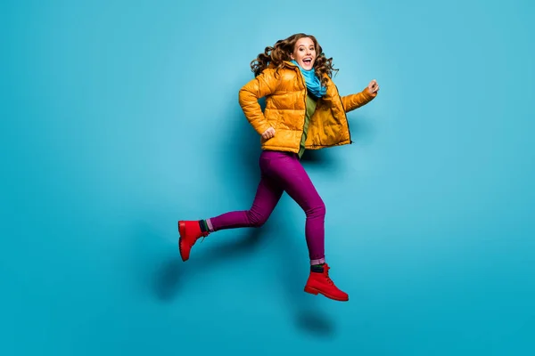 Volledige lichaam profiel foto van mooie dame springen hoge haasten lage prijzen winkelen dragen casual gele overjas sjaal magenta broek rode schoenen geïsoleerde blauwe kleur achtergrond — Stockfoto