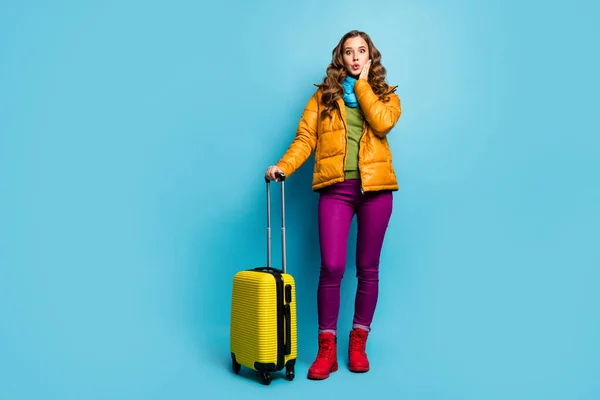 Foto de corpo inteiro de boa senhora viajante espera saco rolante aeroporto voo registo longa grande fila desgaste amarelo sobretudo azul cachecol calças sapatos isolado azul cor fundo — Fotografia de Stock