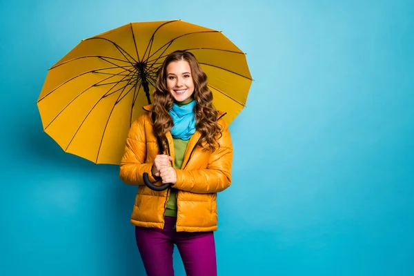Foto de señora bonita mantenga paraguas brillante disfrutar de día soleado caminar calle buen humor desgaste abrigo amarillo bufanda azul pantalones violeta aislado color azul fondo — Foto de Stock