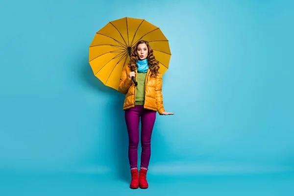 Foto de tamaño completo de la señora viajera bonita celebrar paraguas brillante disfrutar de la temporada soleada día cálido paseo calle desgaste abrigo amarillo bufanda pantalones violeta zapatos rojos aislados color azul fondo — Foto de Stock