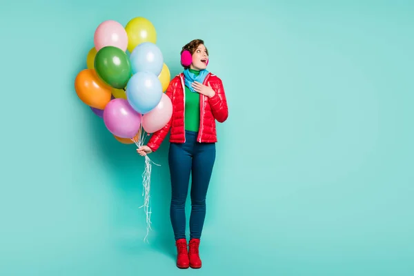 Wow. Full size photo of emotional lady surprise birthday party colorful air balloons look empty space wear casual red coat scarf pink ear muffs pants boots isolated teal color background