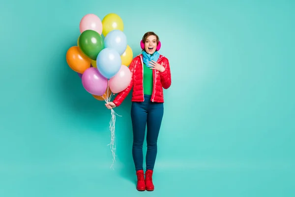 Foto de larga duración de la emoción divertida fiesta de cumpleaños inesperada dama muchos globos de aire coloridos sorpresa desgaste casual abrigo rojo bufanda rosa orejeras pantalones botas aisladas color verde azulado fondo — Foto de Stock