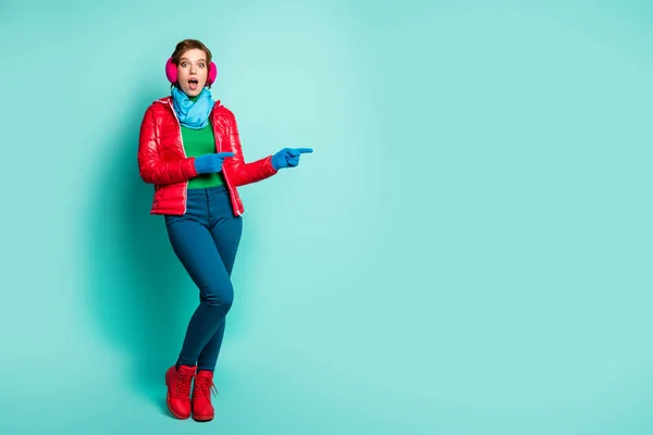 Ganzkörper-Foto der hübschen Dame, die Finger leeren Raum vorschlägt Verkaufspreise schwarz freitag tragen roten Mantel blau Schal rosa Ohrenschützer Hose Schuhe isoliert teal farbe hintergrund — Stockfoto