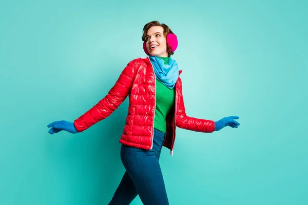 Φωτογραφία προφίλ της αστεία κυρία απολαύσετε τη χειμερινή ημέρα ενεργό πατινάζ ταχύτητας περνούν το χρόνο τους πανηγυρισμούς φορούν κομψό περιστασιακό κόκκινο παλτό μπλε κασκόλ ροζ καλύμματα αυτιών παντελόνι απομονωμένο teal φόντο χρώμα — Φωτογραφία Αρχείου