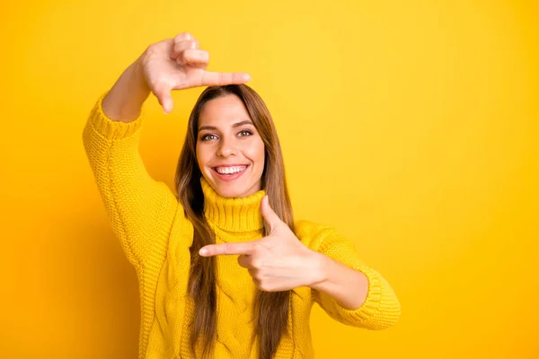 Portrait of charming cheerful girl have idea to make photo with her fingers enjoy focus imagine she successful photographer wear casual style jumper isolated over yellow color background — ストック写真