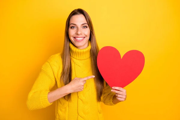 Retrato de menina positiva tem data 14-fevereiro com seu namorado obter vermelho grande papel cartão coração sentir orgulhoso ponto indicador dedo desgaste elegante malha pulôver isolado cor amarela fundo — Fotografia de Stock