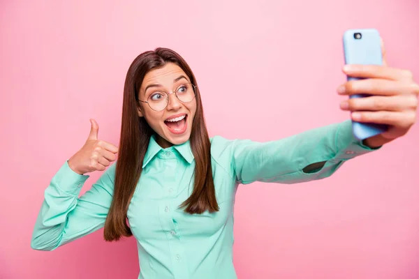 Foto de senhora bonita segurando telefone fazendo selfies levantando dedo polegar para cima aprovar incrível câmera qualidade desgaste especificações teal camisa isolado cor rosa fundo — Fotografia de Stock