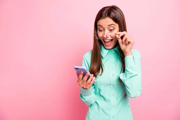 Фото сумасшедшей леди держать телефонные руки читать последователей комментарии, как позитивные реакции открытого рта радость носить очки бирюзовой рубашки изолированы розовый цвет фона — стоковое фото