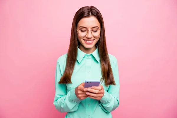 Фото красивої леді, що тримає телефонні руки, читаючи коментарі послідовників, як позитивні реакції носять специфікації сорочки ізольовані рожевий колір фону — стокове фото
