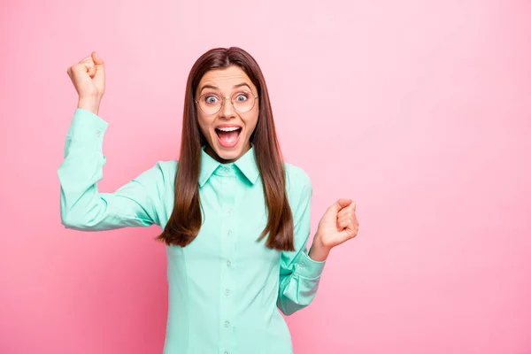 Foto de señora divertida levantando puños celebrando increíble lotería ganando sentimientos extáticos gritando en voz alta usar especificaciones camisa turquesa aislado color rosa fondo —  Fotos de Stock