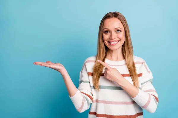 Photo of cheerful positive pretty sweet woman pointing at empty space on her palm smile toothy isolated pastel blue color background — Stock Photo, Image