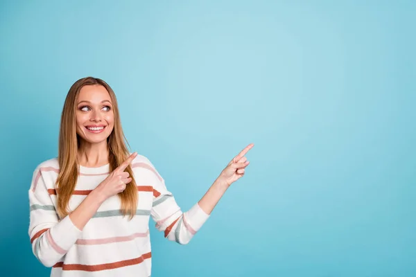 Foto de mujer alegre bastante dulce señalando en el espacio vacío sonrisa dentadura en las ventas buscando fondo de color azul pastel aislado — Foto de Stock