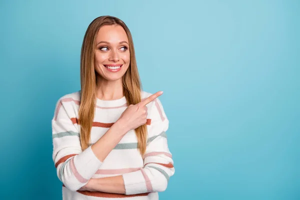 Foto de alegre mujer positiva confiada apuntando hacia el espacio vacío sonriendo con un fondo de color pastel azul aislado — Foto de Stock