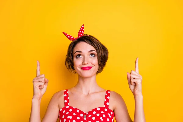 Closeup photo of pretty lady indicate fingers up empty space advising novelty sale price product wear retro style dotted red white tank-top headband isolated yellow color background — 스톡 사진