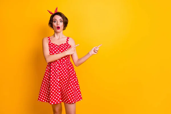 Portrait of astonished crazy girl promoter point index finger copyspace indicate ads incredible promotion impressed scream wow omg wear retro style skirt isolated yellow color background — 스톡 사진