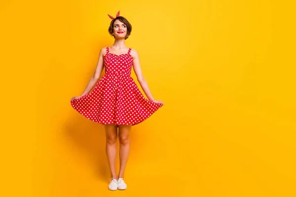 Plná délka fotografie krásné spokojené dívky vzhled těšit jaro volný čas dovolená vzhled copyspace dotknout její polka-dot sukně nosit bílé tenisky izolované přes lesk barvy pozadí — Stock fotografie