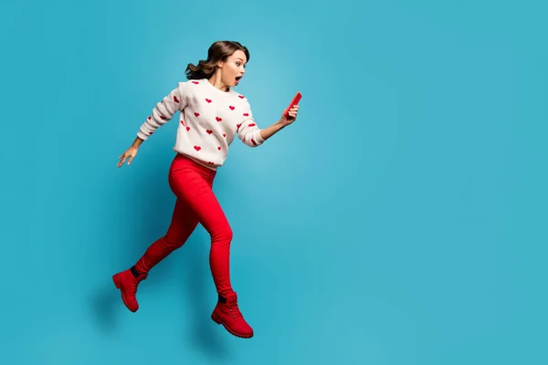 Teljes hosszúságú testméret kilátás rá ő szép vonzó lenyűgözött lány jumping segítségével modul olvasás hamis hírek futás rohanás elszigetelt fényes élénk ragyogás élénk kék szín háttér — Stock Fotó