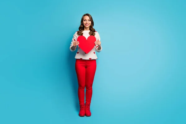 Longitud completa tamaño del cuerpo vista de agradable atractivo adorable alegre alegre tierna chica de ensueño con ropa festal sosteniendo en la mano gran corazón aislado en brillante brillo vivo vibrante color azul fondo —  Fotos de Stock