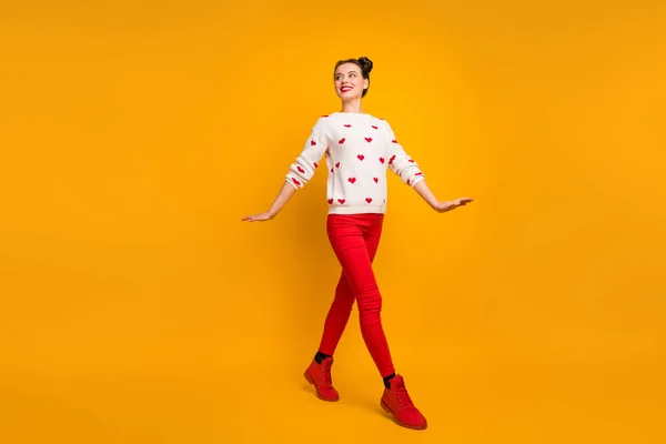 Teljes test profil fotó elég vicces hölgy séta utca vidám jókedv utazó külföldön visel szív minta pulóver piros nadrág cipő elszigetelt sárga szín háttér — Stock Fotó